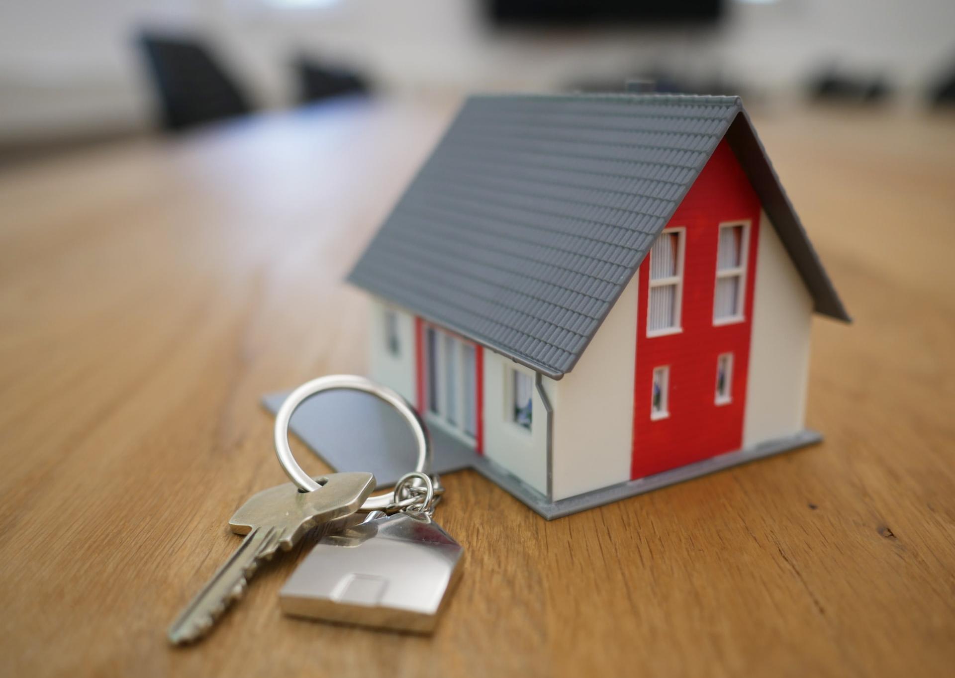 white and red wooden house miniature on brown table